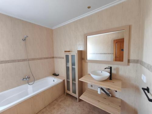 a bathroom with a tub and a sink and a mirror at Villa Pepita in Torrent