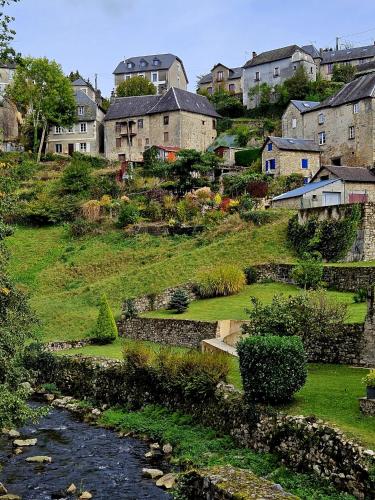 un village avec des maisons et une rivière avec des bâtiments dans l'établissement Aux Grandes Rivieres, à Madranges