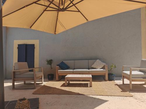 - un salon avec un canapé, des chaises et un parasol dans l'établissement Lamaisonbleue, à Auriol
