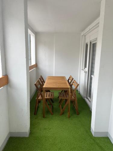 - une table et des chaises dans une pièce dotée d'une moquette verte dans l'établissement Spacieux et confortable - centre ville de BRIANCON - SERRE-CHEVALIER - Garage et Wifi, à Briançon