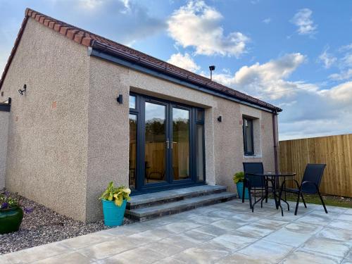 Un patio de una casa con una mesa y sillas. en The Wee Hoose, en Fife