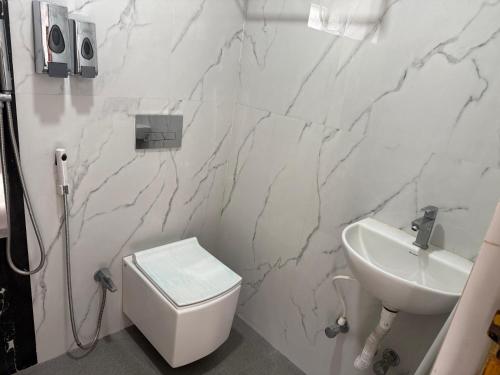 Un baño blanco con lavabo e inodoro. en Modern, Stylish & Luxurious 1 BHK stay,22, en Bhubaneshwar