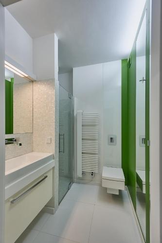 a bathroom with a sink and a shower with green accents at Apartamenty Świnoujście - Rezydencja Sienkiewicza in Świnoujście