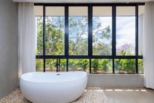 Villa Luxury Hồ Bơi View Biển Bãi trước Vũng Tàu في فنغ تاو: حوض أبيض كبير في غرفة مع نافذة كبيرة