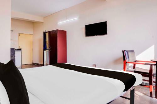 a bedroom with a bed and a tv on the wall at Collection O Anjuna 5 Mins Walk From Anjuna in Anjuna