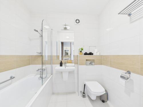 a bathroom with a tub and a toilet and a sink at Galopu 7 SuperApart - Blisko lotniska i toru Służewiec in Warsaw