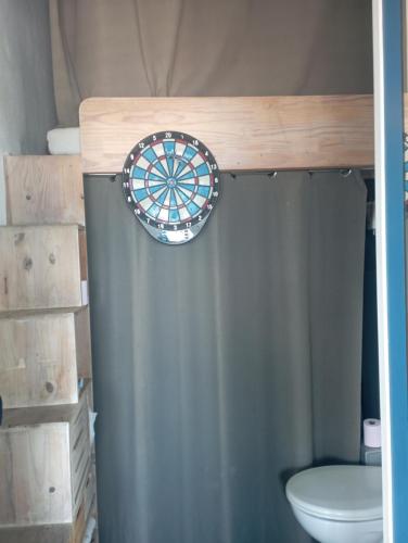 une salle de bain avec un jeu de fléchettes au-dessus des toilettes dans l'établissement Face à la mer, appartement pour 4 personnes sur la rive droite, à Palavas-les-Flots