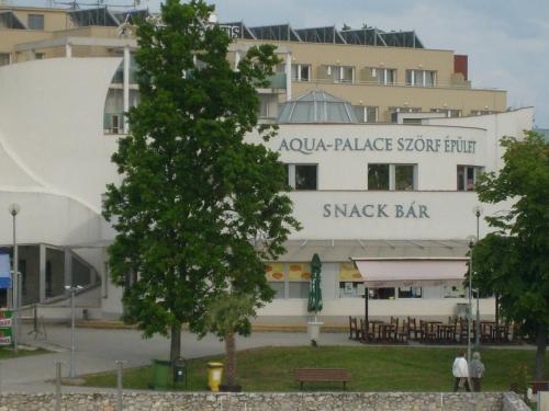 a building with a sign that reads akura palace your hotel smack bar at Otthon Apartman in Hajdúszoboszló