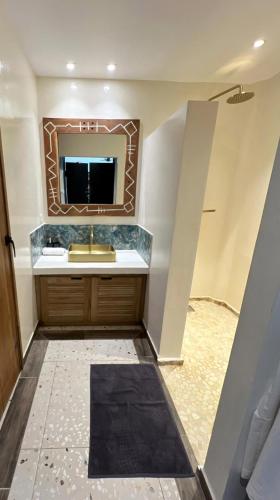 a bathroom with a sink and a mirror at Agence Adjana Resort - Résidence du Port 3 in Sali Tapé