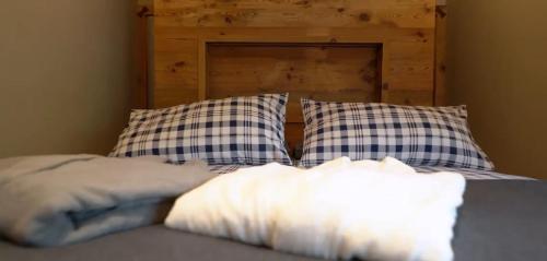 a bed with blue and white pillows on it at Appartamento La Mirage in Livigno