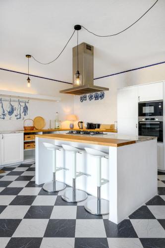 a kitchen with white cabinets and a checkered floor at Monte da Vista Alegre in Elvas