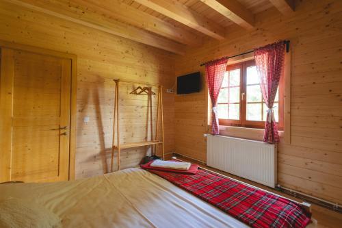 a bedroom with a bed in a log cabin at Casute cu cerdac in Şarul Dornei