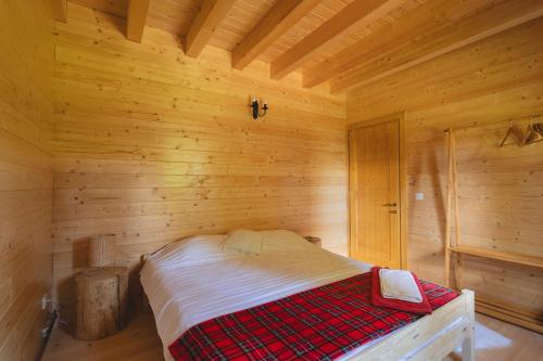 a bedroom with a bed in a wooden room at Casute cu cerdac in Şarul Dornei