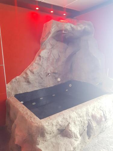 a bath tub in a room with a rock wall at Hotel La Fayette Giugliano Licola in Giugliano in Campania