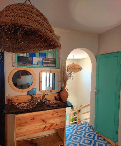 a bathroom with a sink and a mirror at Moroccan Boho Surf House in Agadir