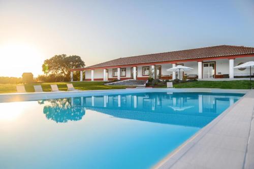 a swimming pool in front of a house at Monte da Vista Alegre in Elvas