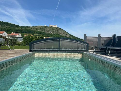 a swimming pool with two chairs sitting next to it at Apartmány Maidenburg in Pavlov