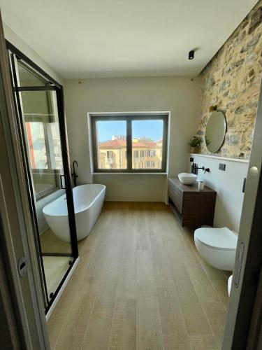 a bathroom with a tub and a toilet and a sink at Le Boulevard Suites & Apartments in Olbia