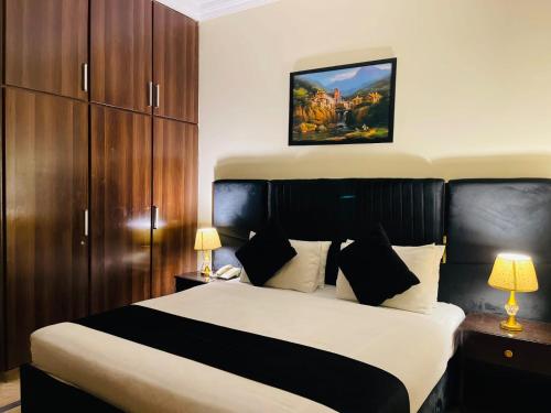 a bedroom with a large bed with wooden cabinets at Infinity Hotel in Lahore
