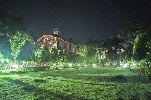 a large house at night with a large yard at Whispering Woods Inn - Stay & Enjoy in Nature ! in Bolpur