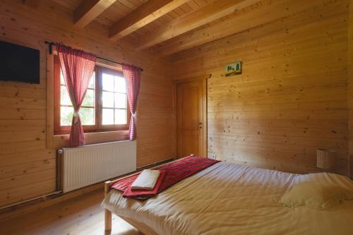a bedroom with a bed in a wooden room at Casute cu cerdac in Şarul Dornei