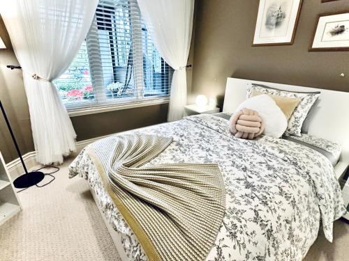 a bedroom with a bed with a blanket and a window at Scorpion Hiuse Langley -ROOM 1 Separate restroom in Pitt Meadows