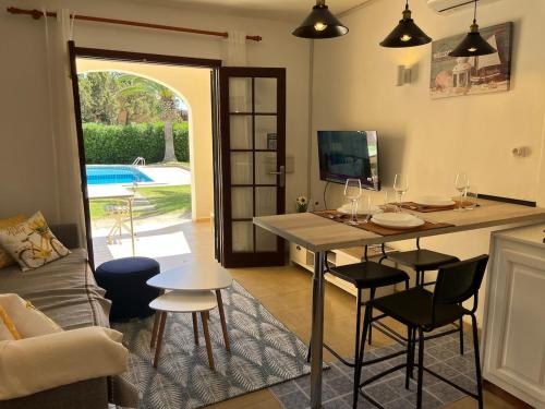 Reserva septiembre,octubre Apartamento piscina y playa junto Cap D Artrutx cerca Ciudadela في سون كسورغير: مطبخ وغرفة معيشة مع طاولة وكراسي