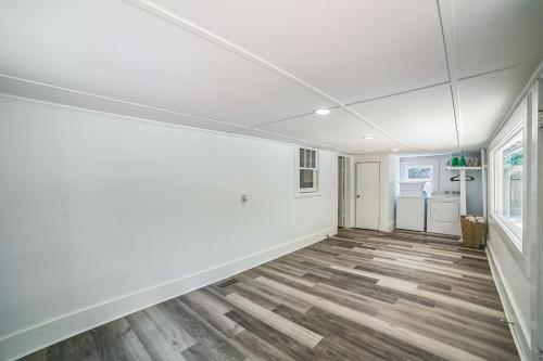 an empty room with white walls and wood floors at Magnolia House Walk to Festival Park home in Nacogdoches