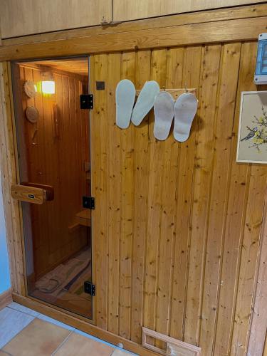 a wooden room with white slippers on the wall at La villa Lambert-Longière in Monnai