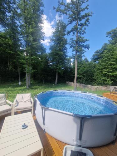 a bath tub on a deck with a table and chairs at Chill Chaty in Tarnobrzeg