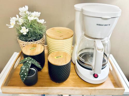 a coffee maker on a wooden tray with flowers at Scorpion Hiuse Langley -ROOM 1 Separate restroom in Pitt Meadows