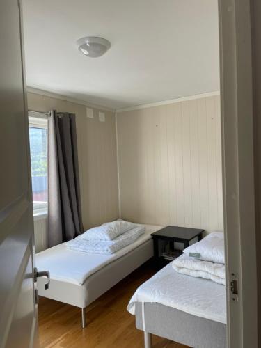 two beds in a small room with a window at Signegarden in Skjåk