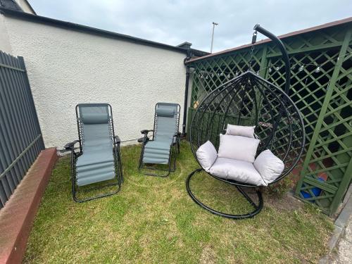 three chairs and a swing in a yard at Błękitna fala in Mielno