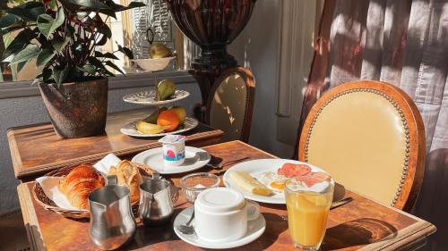 une table avec des aliments et des boissons pour le petit-déjeuner dans l'établissement Hôtel Belle Meunière, à Nice
