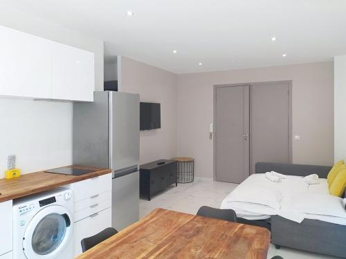 une cuisine avec une table et une machine à laver dans l'établissement Residence le Courbet, à Juan-les-Pins