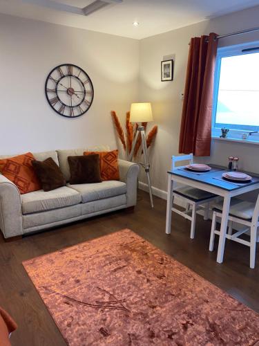 a living room with a couch and a table at Hazelmount Self-Catering Cabin in Portree