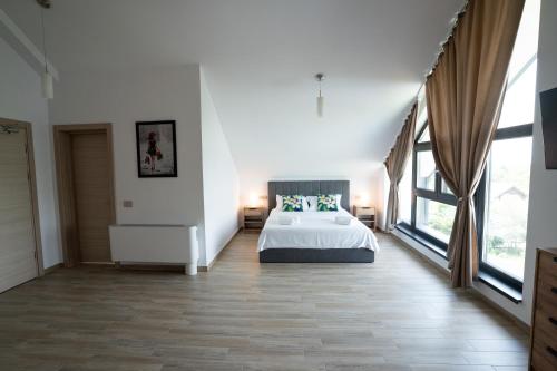 a large bedroom with a bed and large windows at INDRA WELLNESS Retreats and Spa in Samurcaşi