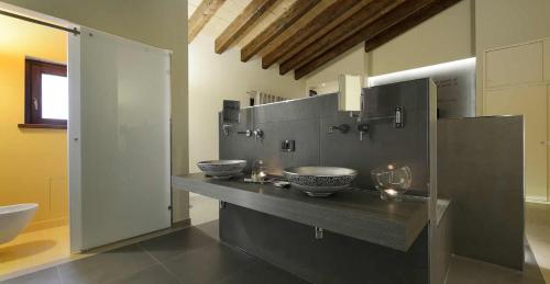 a bathroom with two sinks and two bowls on a counter at Agrirelais Principe SPA in San Giuseppe Jato