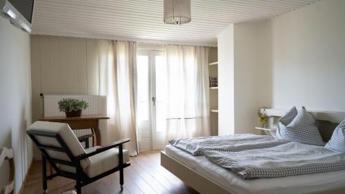 a bedroom with a bed and a chair and a desk at Pension Hanslmann in Steinbach am Attersee
