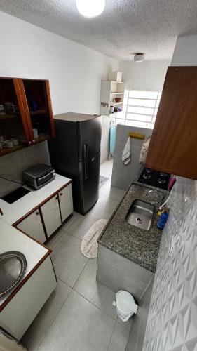 a kitchen with a refrigerator and a counter top at Apartment near UFMS in Campo Grande