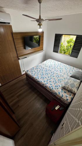 a small bedroom with a bed and a tv at Apartment near UFMS in Campo Grande