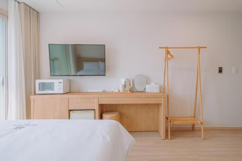 a bedroom with a bed and a television on a table at Jeju Mon Dieu Hotel in Jeju