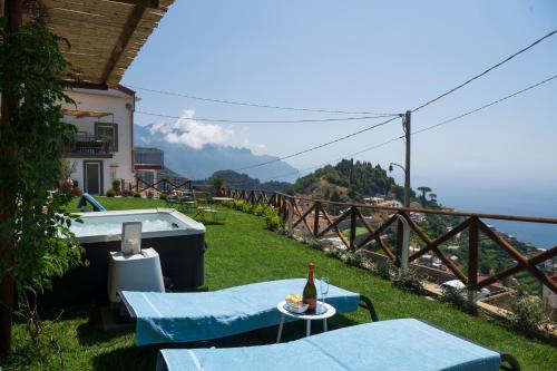 a patio with a table and a bottle of beer at Dimora la Fenice Ambra Apartment in Amalfi