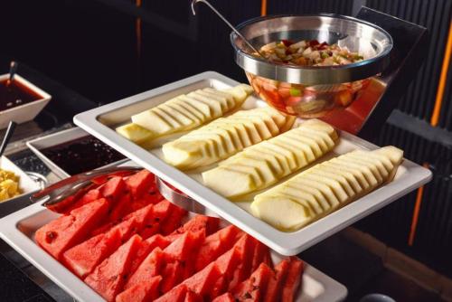 a table with several trays of pastries and other foods at Skyline Apartments Batumi in Batumi
