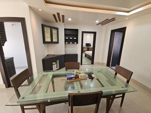 a dining room with a glass table and chairs at The Monarch Riverview 2BHK in Guwahati