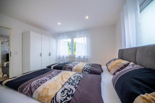 a bedroom with two beds and a window at Sixtn Apartments Bühlertal in Bühlertal