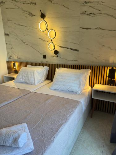 a bedroom with a large bed and a chandelier at Milka Studios in Barbati