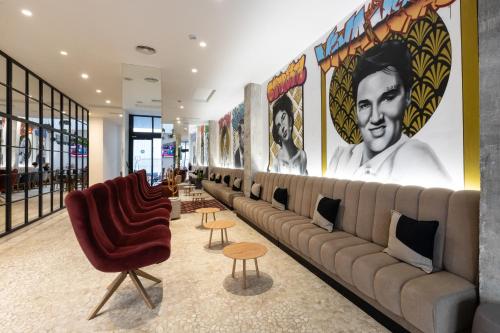 a lobby with a long line of chairs and posters at Dormirdcine Alicante in Alicante