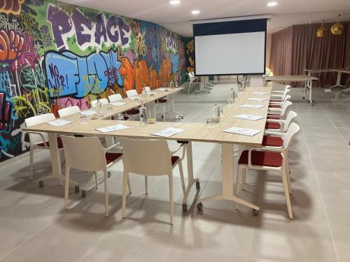 a conference room with tables and chairs and a whiteboard at Dormirdcine Alicante in Alicante