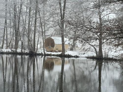 a house sitting on the side of a lake in the snow at Brösarp Källagården Vindsvåning 2 rum och kök in Brösarp